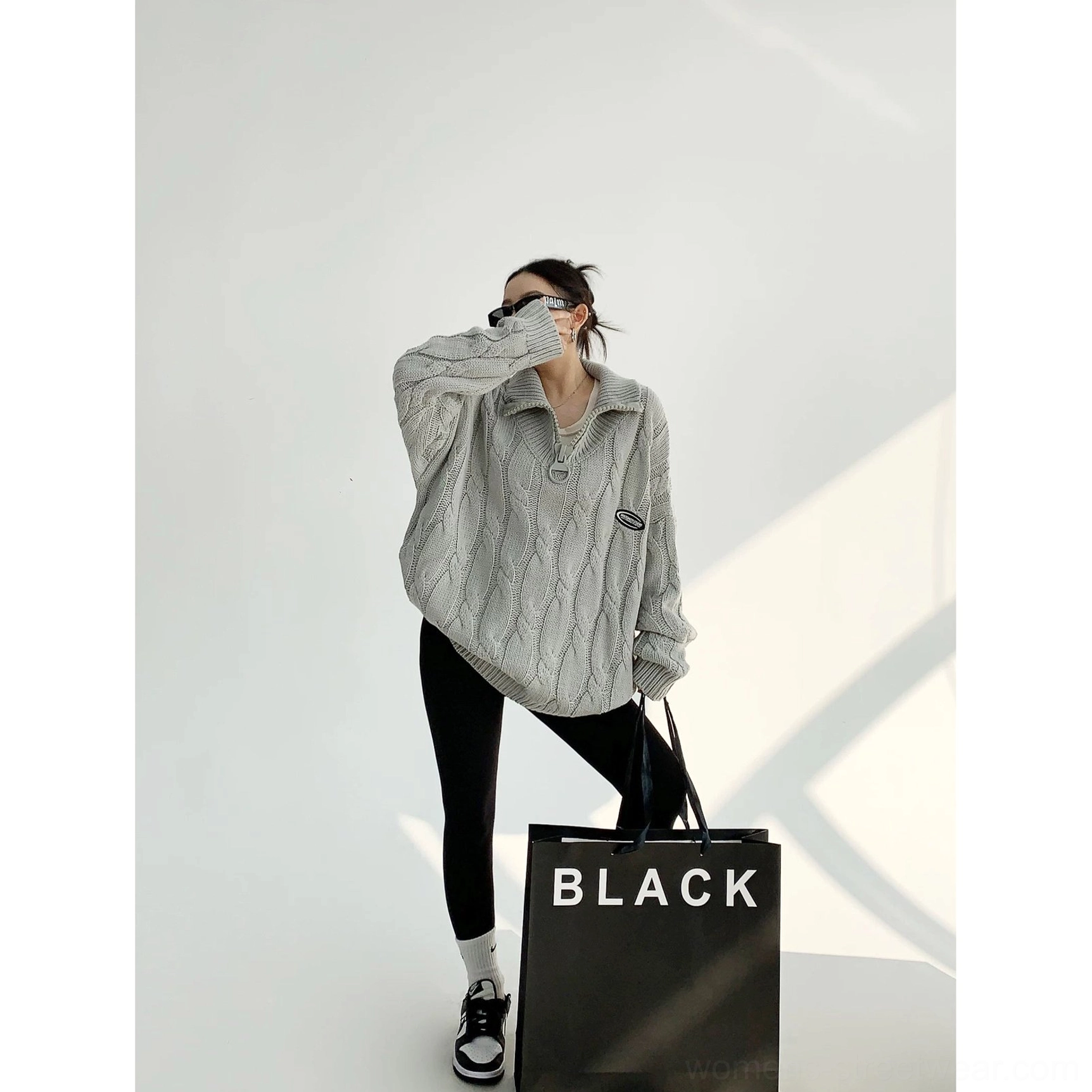 Gray oversized cable knit quarter-zip sweater with stand collar and relaxed streetwear silhouette