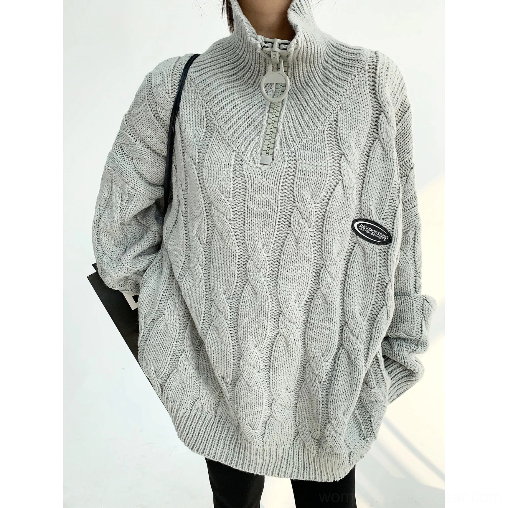 Gray oversized cable knit quarter-zip sweater flat lay showing high collar cable texture and chest detail
