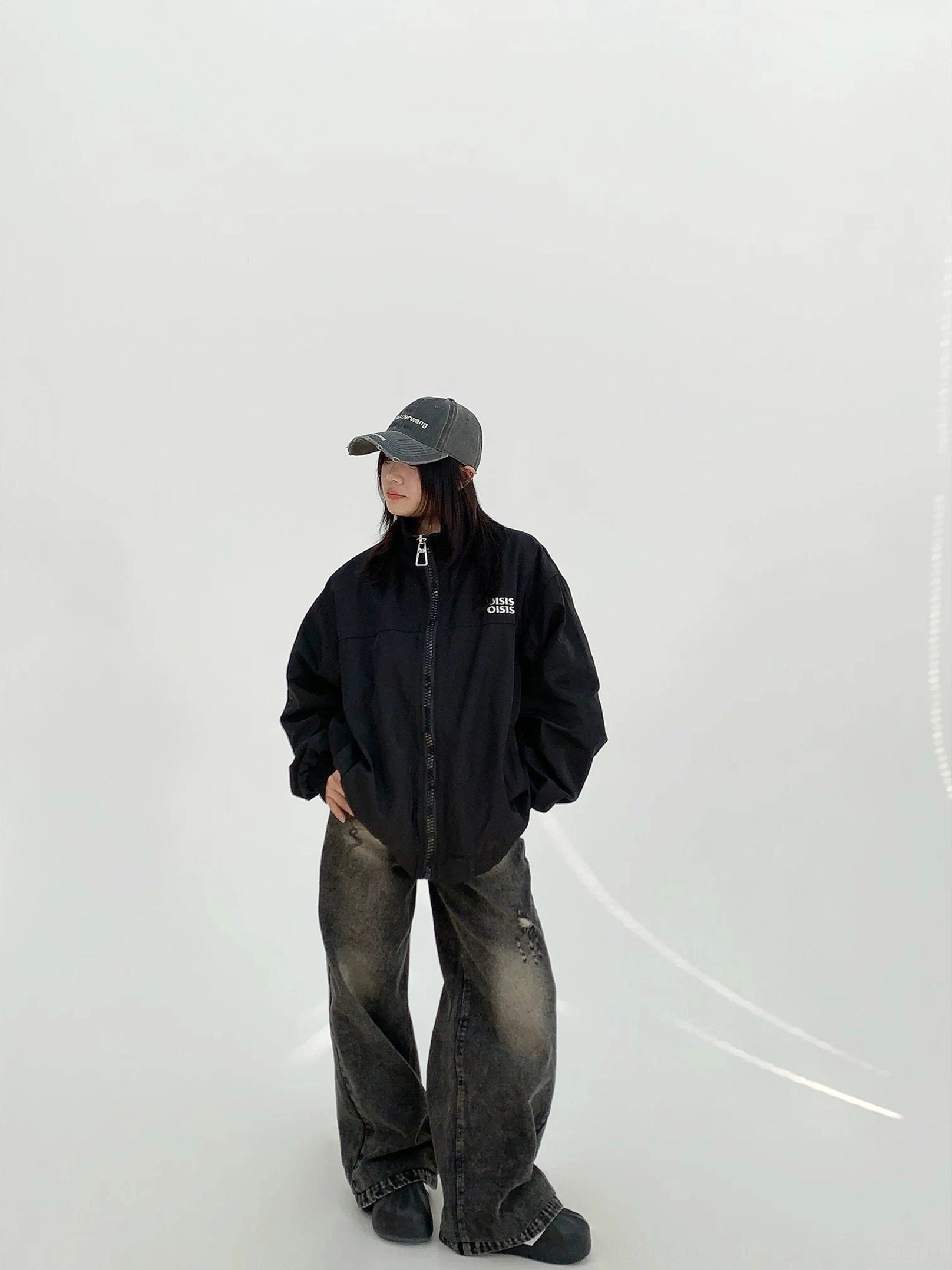 Black women's oversized cloud shell windbreaker jacket shown from side front view with relaxed dropped-shoulder streetwear fit