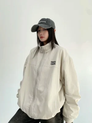 Off-white oversized cloud shell windbreaker jacket for women shown in front three-quarter view with stand collar and wide-leg jeans