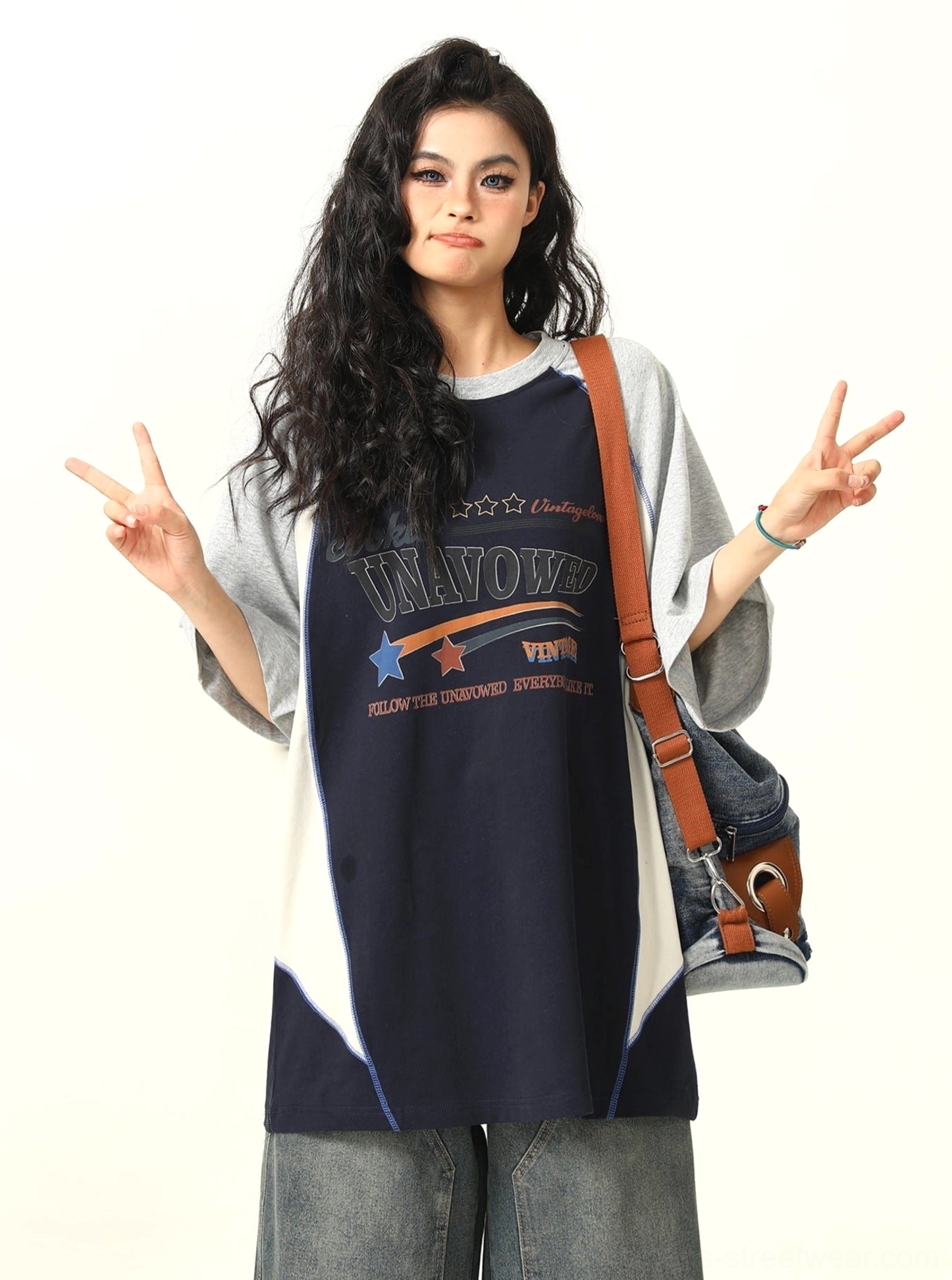 Blue oversized raglan graphic T-shirt with grey contrast sleeves and white side trim three-quarter view