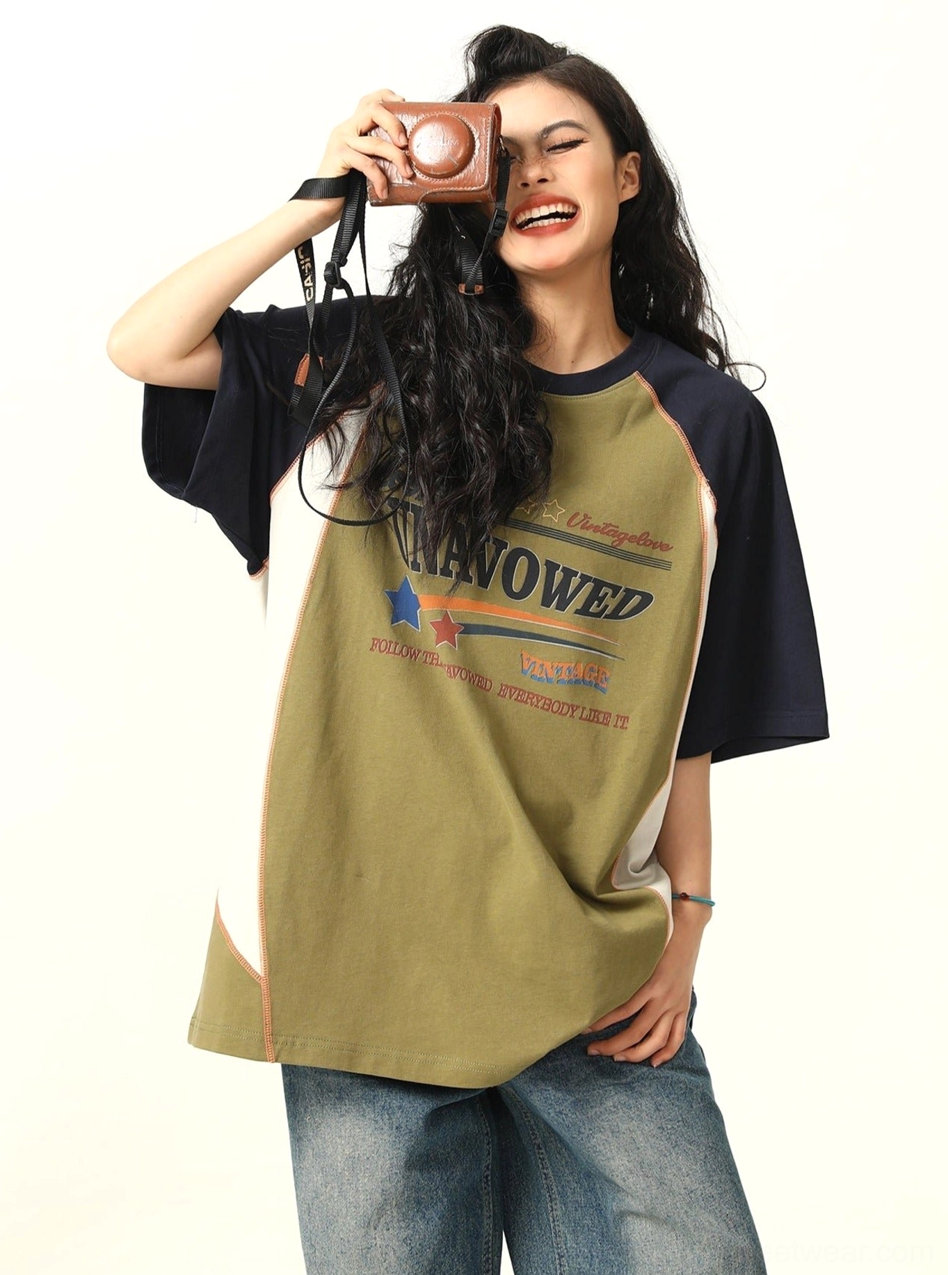 Green oversized streetwear raglan T-shirt featuring navy sleeves and vintage inspired chest graphic