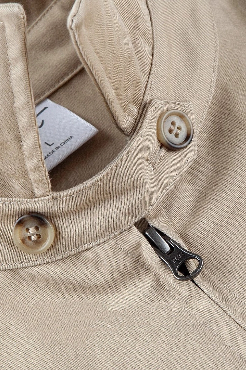 Close-up detail of cotton twill work jacket fabric metal zipper puller collar button and utility construction