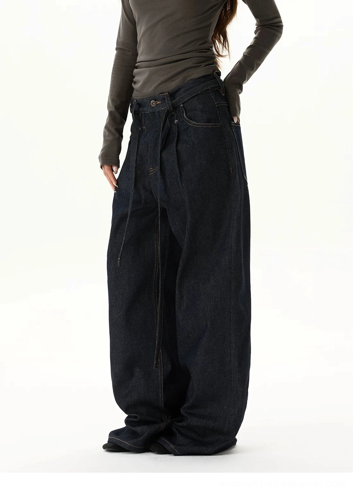 Oversized dark blue balloon-leg jeans featuring extra-long stacked hems, relaxed proportions, and contemporary avant-garde streetwear styling