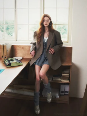 Earth color oversized double-breasted checked streetwear blazer shown in a three-quarter front layered denim dress outfit