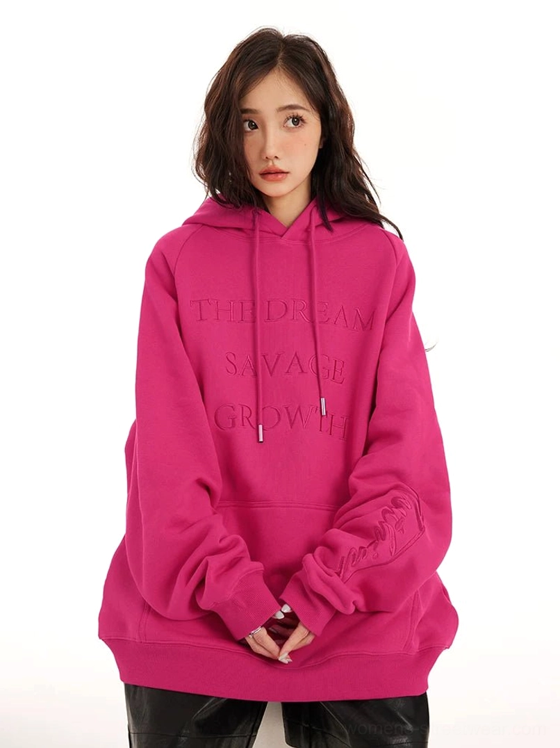 Oversized embossed lettering pullover hoodie in vibrant pink with tonal front and sleeve graphics, adjustable hood, and relaxed streetwear fit