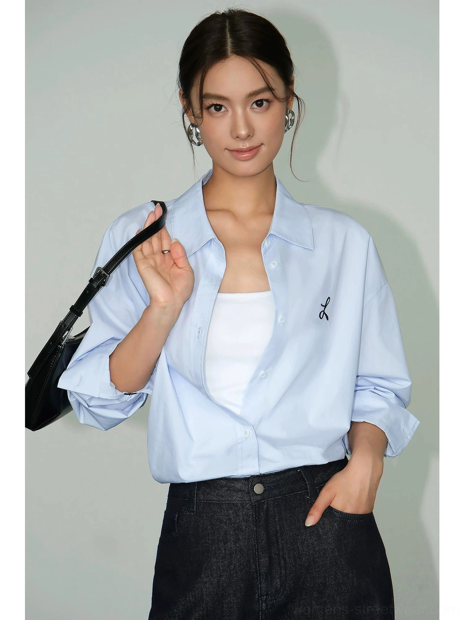 Light blue oversized embroidered button-down shirt layered over white tube top and black jeans