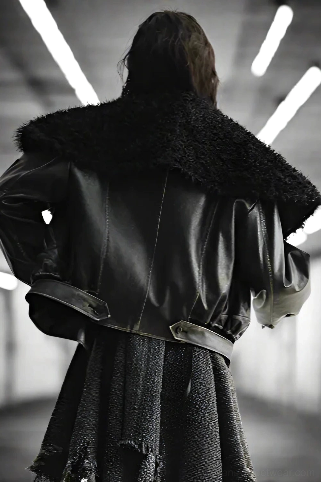 Back view of an oversized faux fur aviator jacket showing the plush collar, vintage distressed finish, and adjustable waist strap