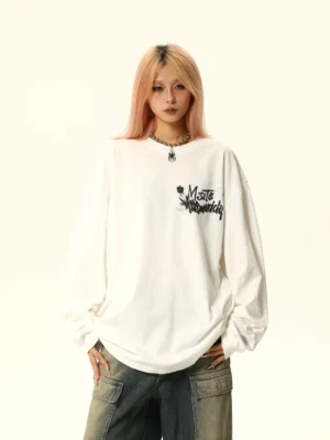 White oversized graffiti graphic long sleeve tee with black chest print, relaxed drop shoulders, and Korean streetwear styling
