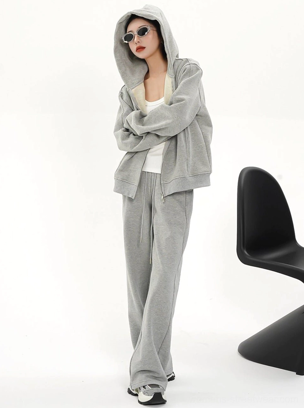Oversized gray women's zip-up hoodie jacket with hood worn up and relaxed matching casual streetwear styling
