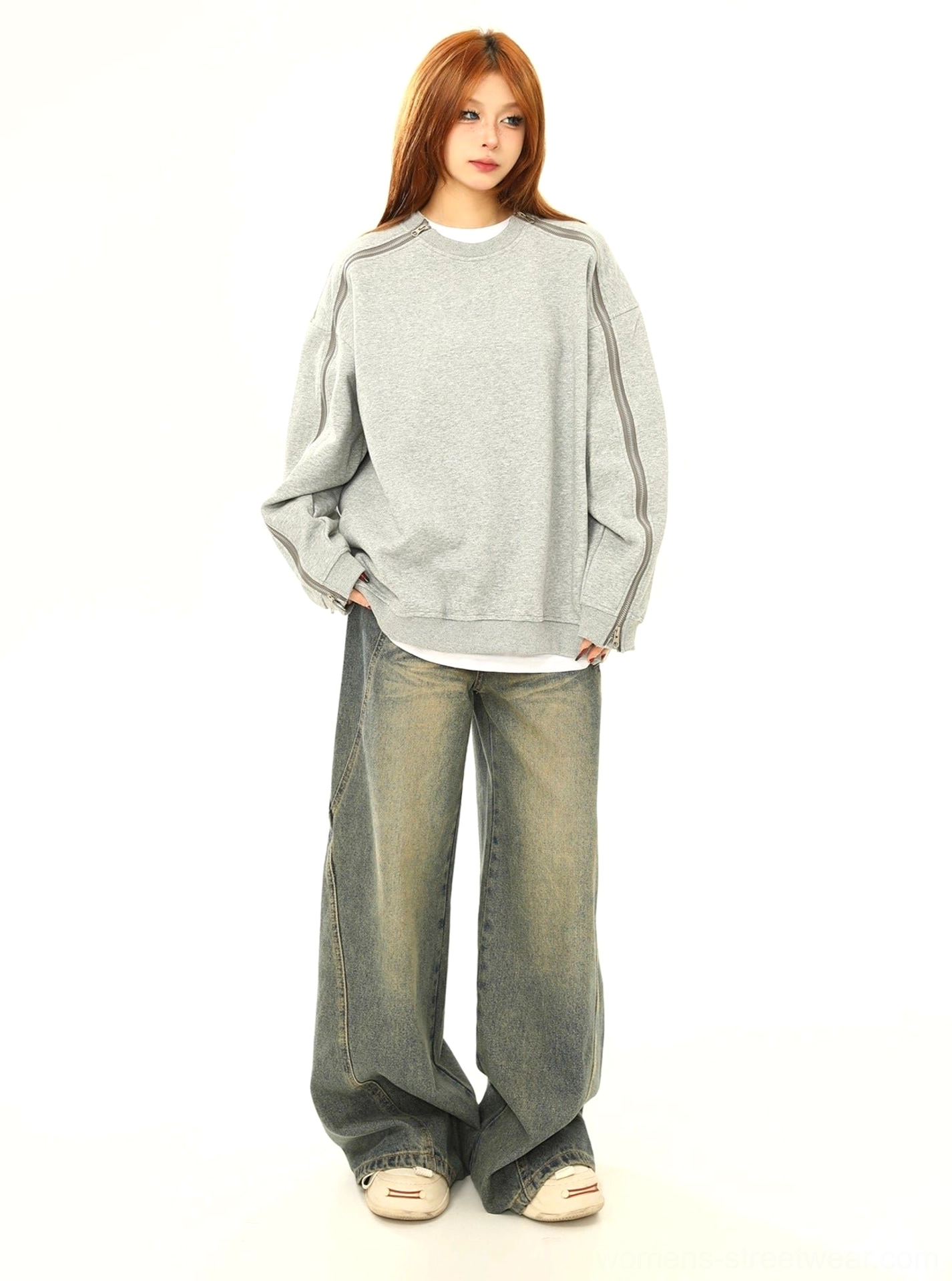 Side view of oversized gray zip sleeve sweatshirt styled with wide leg jeans and white sneakers