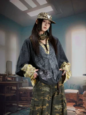 Dark gray oversized fake two piece knit pullover with distressed graffiti print plaid collar and layered cuffs styled with camouflage cargo pants