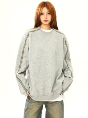 Oversized heather gray zip sleeve crewneck sweatshirt worn by female model in front view