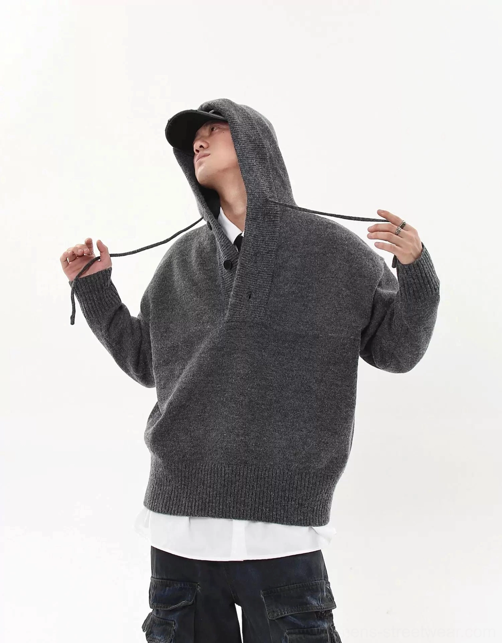 Heather gray oversized knit hoodie sweater front close-up showing adjustable drawstrings, soft knitted texture, and layered styling