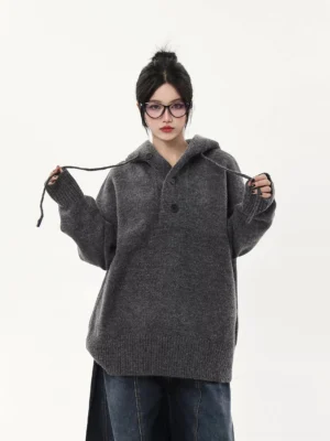 Heather gray oversized knit half-button hoodie sweater close-up showing soft knit texture, drawstring hood, and relaxed fit