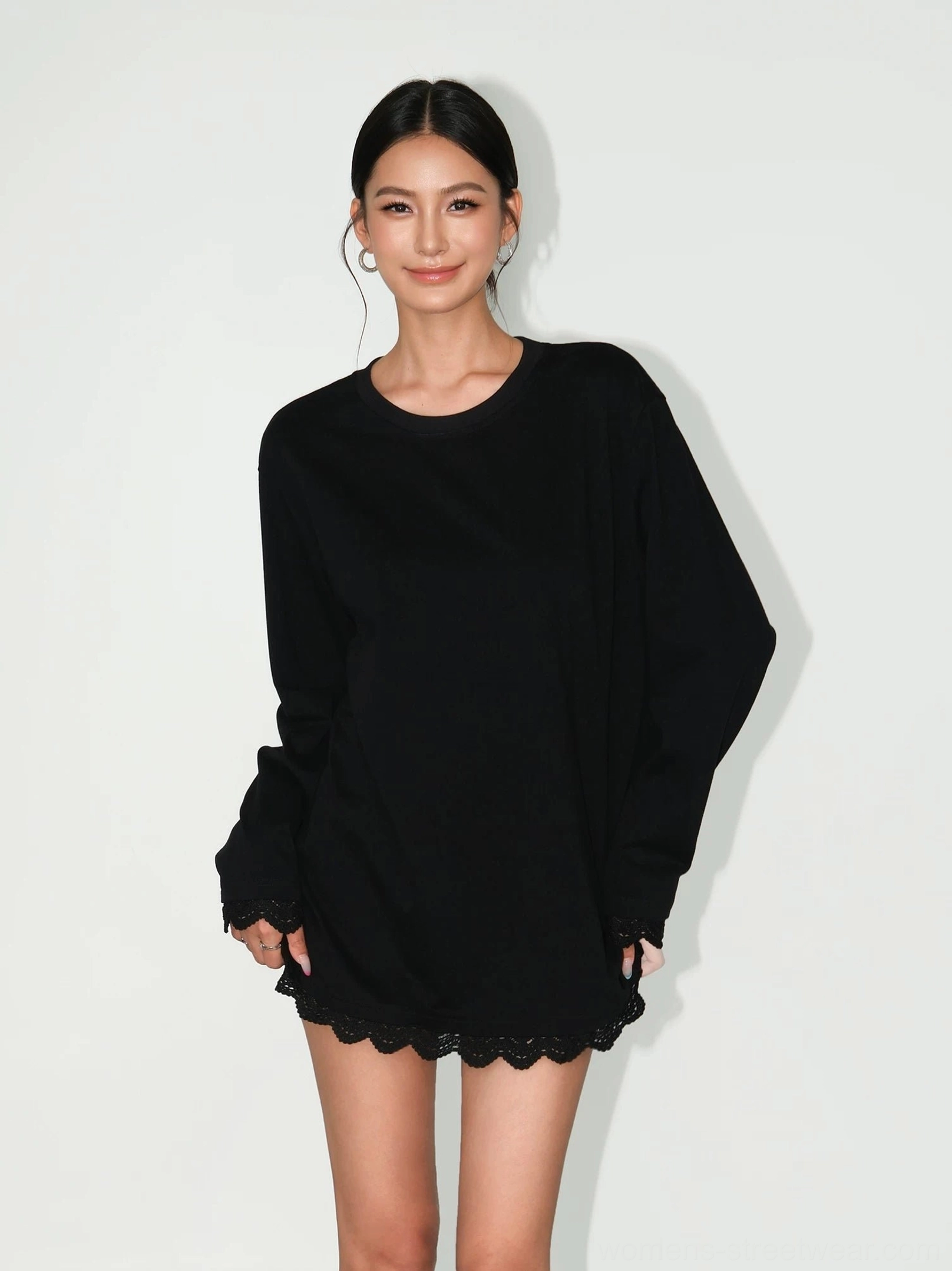 Black oversized lace-hem long-sleeve tee dress with scalloped black lace trim, relaxed crew neck silhouette shown from the front