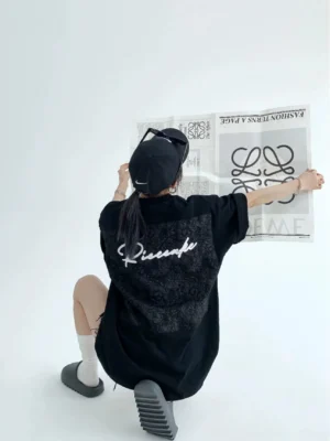 Black oversized lace panel script streetwear tee back view with tonal floral appliqué and white cursive lettering