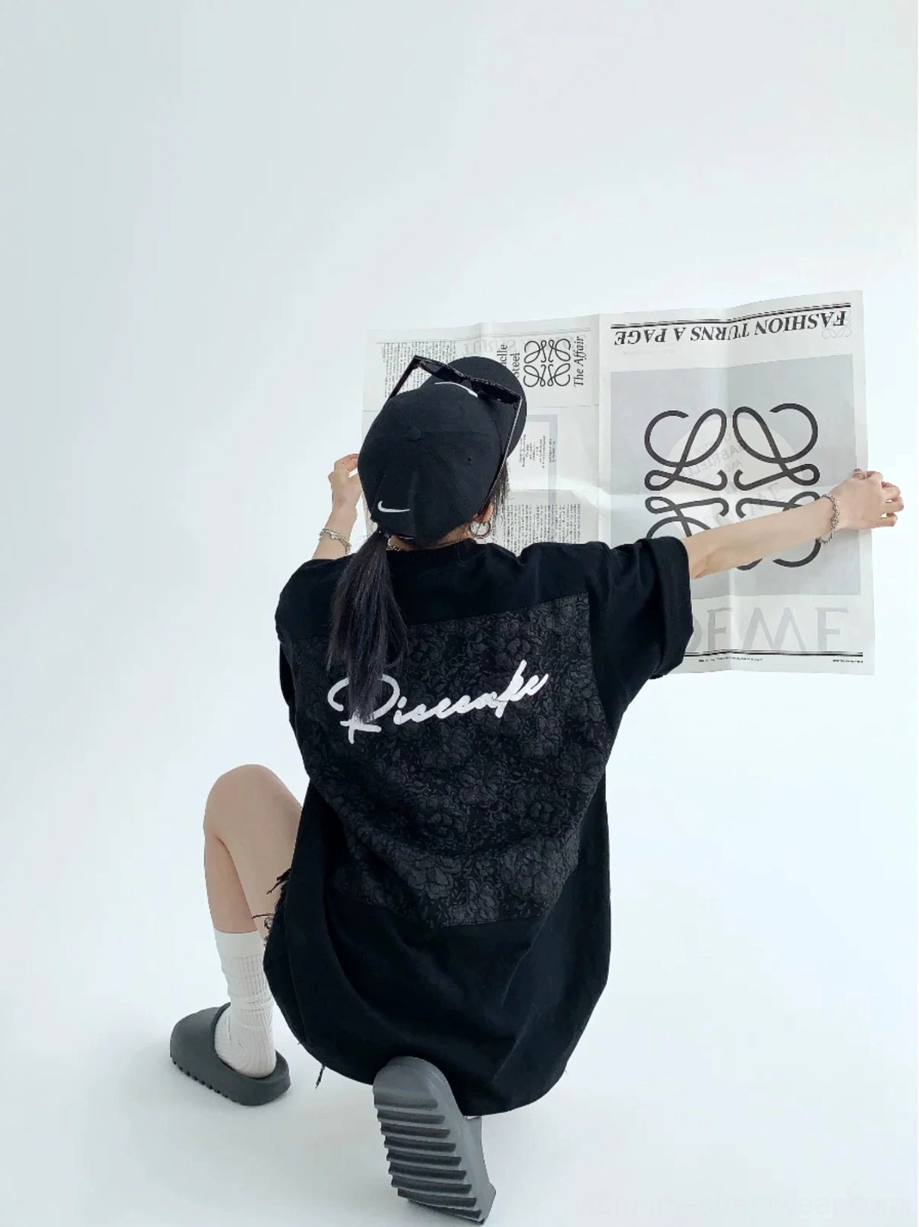 Black oversized lace panel script streetwear tee back view with tonal floral appliqué and white cursive lettering