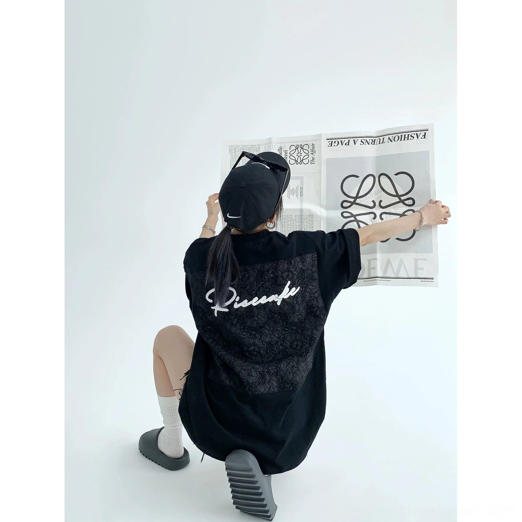 Black oversized lace panel script streetwear tee product view featuring tonal floral back appliqué and white script