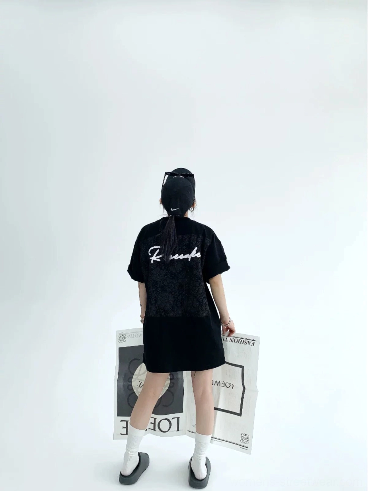 Black oversized script T-shirt rear full body view showing tonal floral lace back panel and bold white script