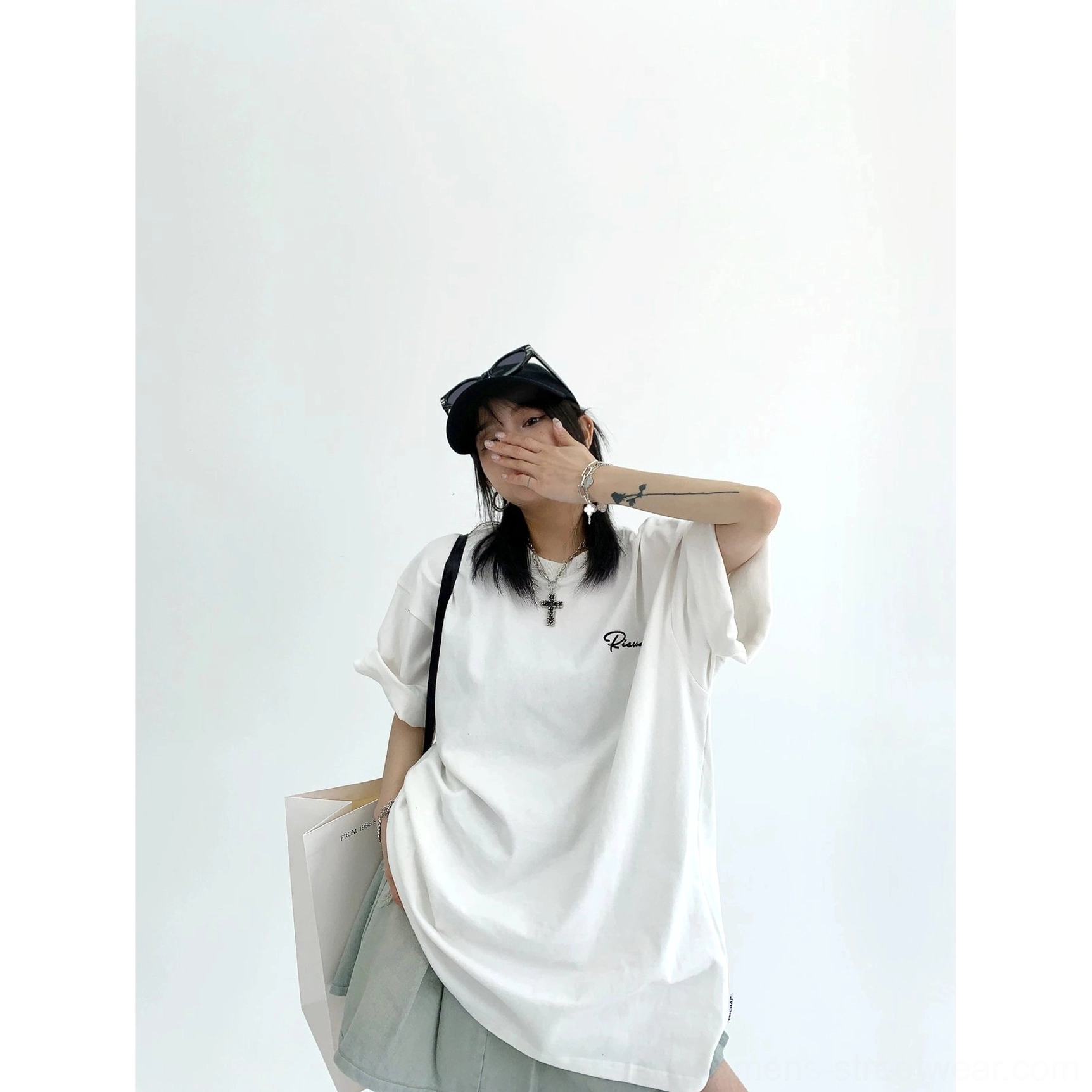 White oversized lace panel script streetwear tee front view with small black cursive chest embroidery