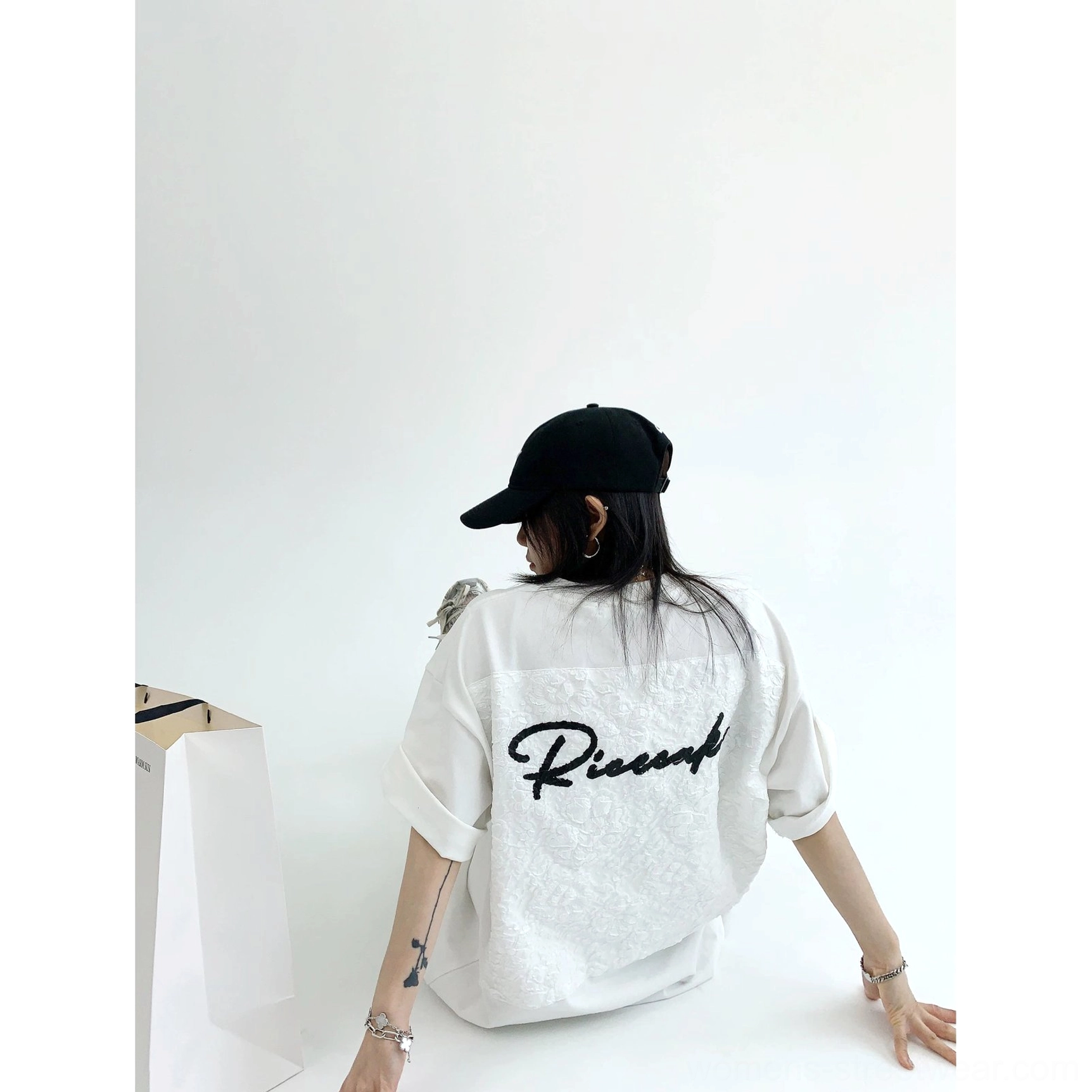 White oversized floral lace appliqué back T-shirt rear low angle view with black script lettering