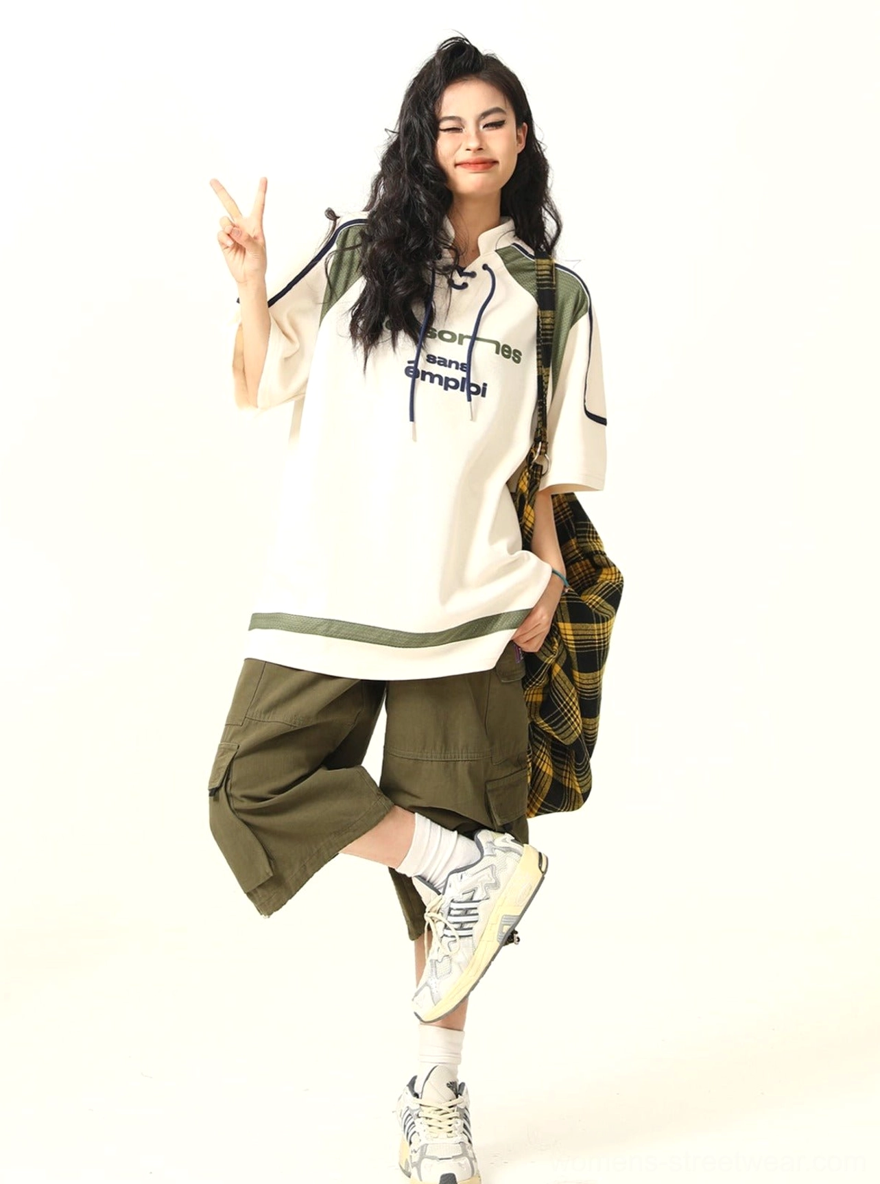 Front three-quarter view of oversized lace-up collar varsity graphic T-shirt on female model