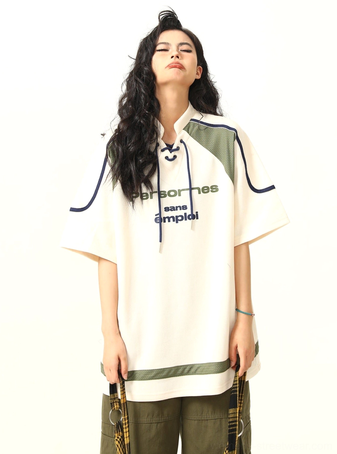 Female model wearing oversized lace-up collar sports graphic T-shirt with varsity-style print