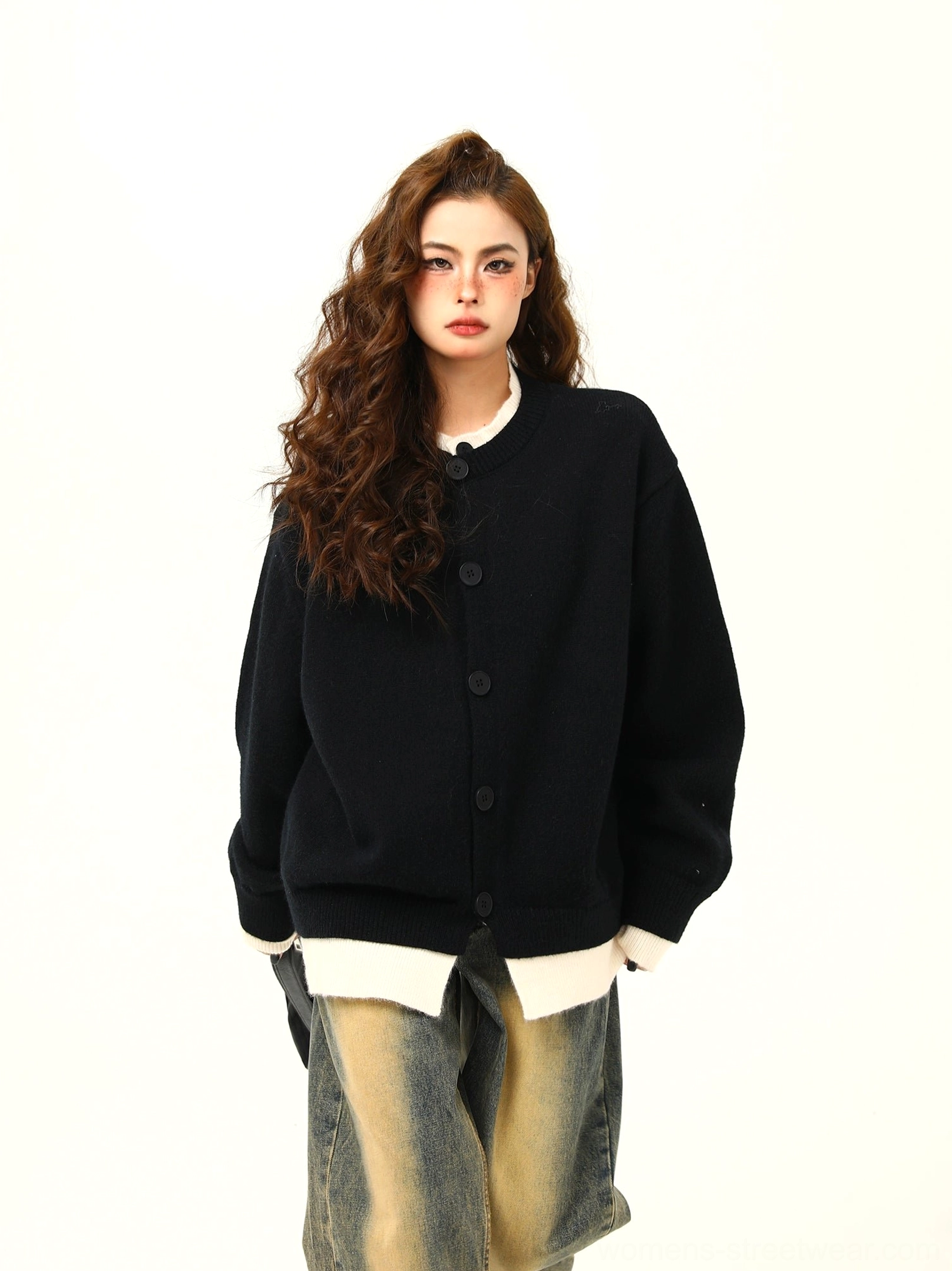 Black oversized button knit cardigan with white layered hem styled with yellow wash wide leg denim
