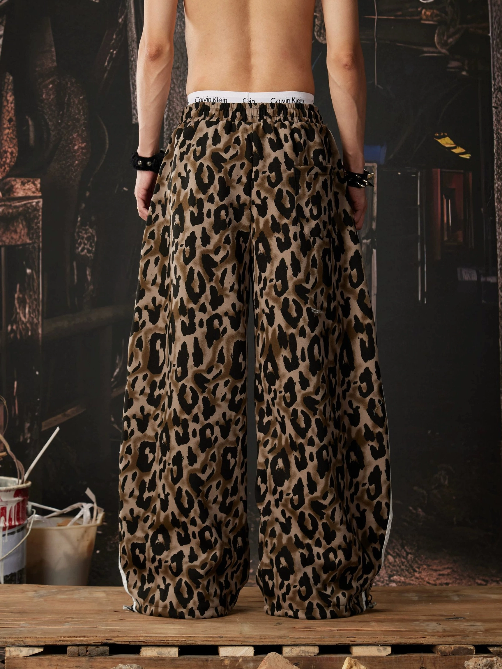 Back view of oversized leopard print track pants with relaxed wide leg streetwear silhouette