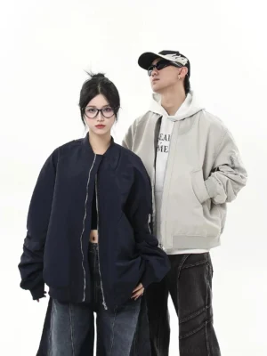 Oversized modular flight bomber jacket in gray and navy shown in a full body studio streetwear group look