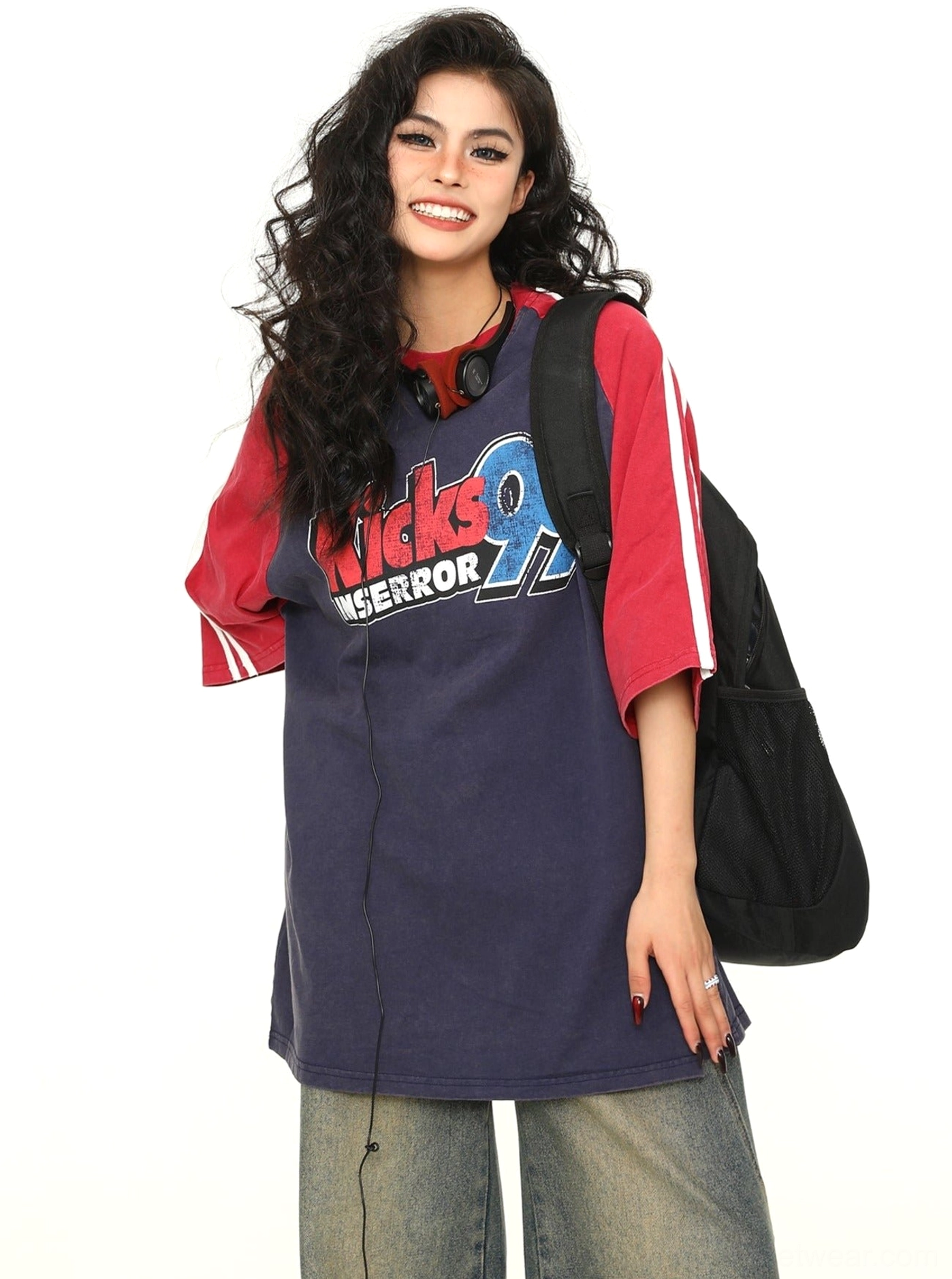 Side-front view of an oversized navy baseball graphic T-shirt with red raglan sleeves and white stripe details