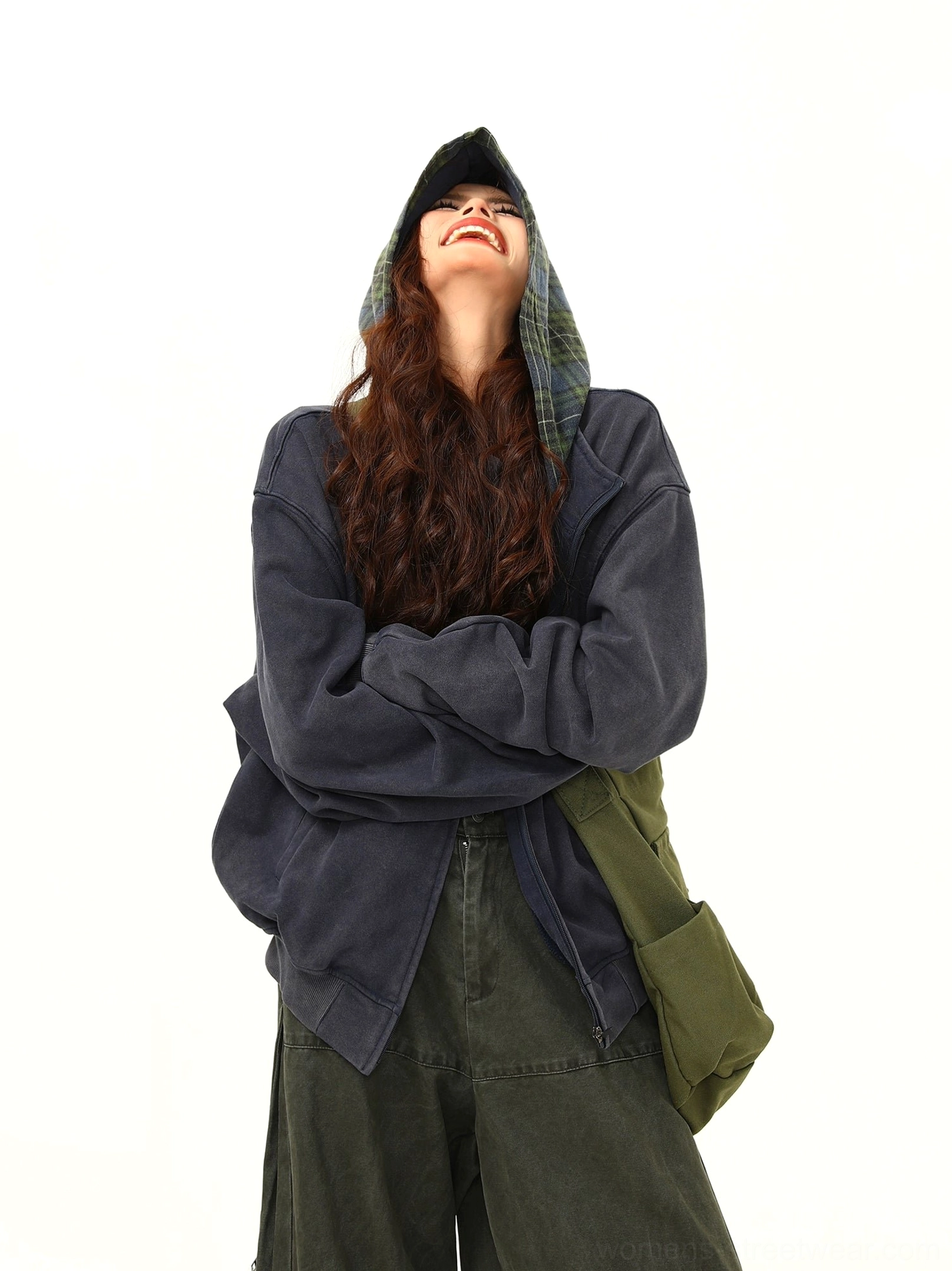 Front view of an oversized navy zip jacket with the hood raised to reveal contrasting green plaid lining