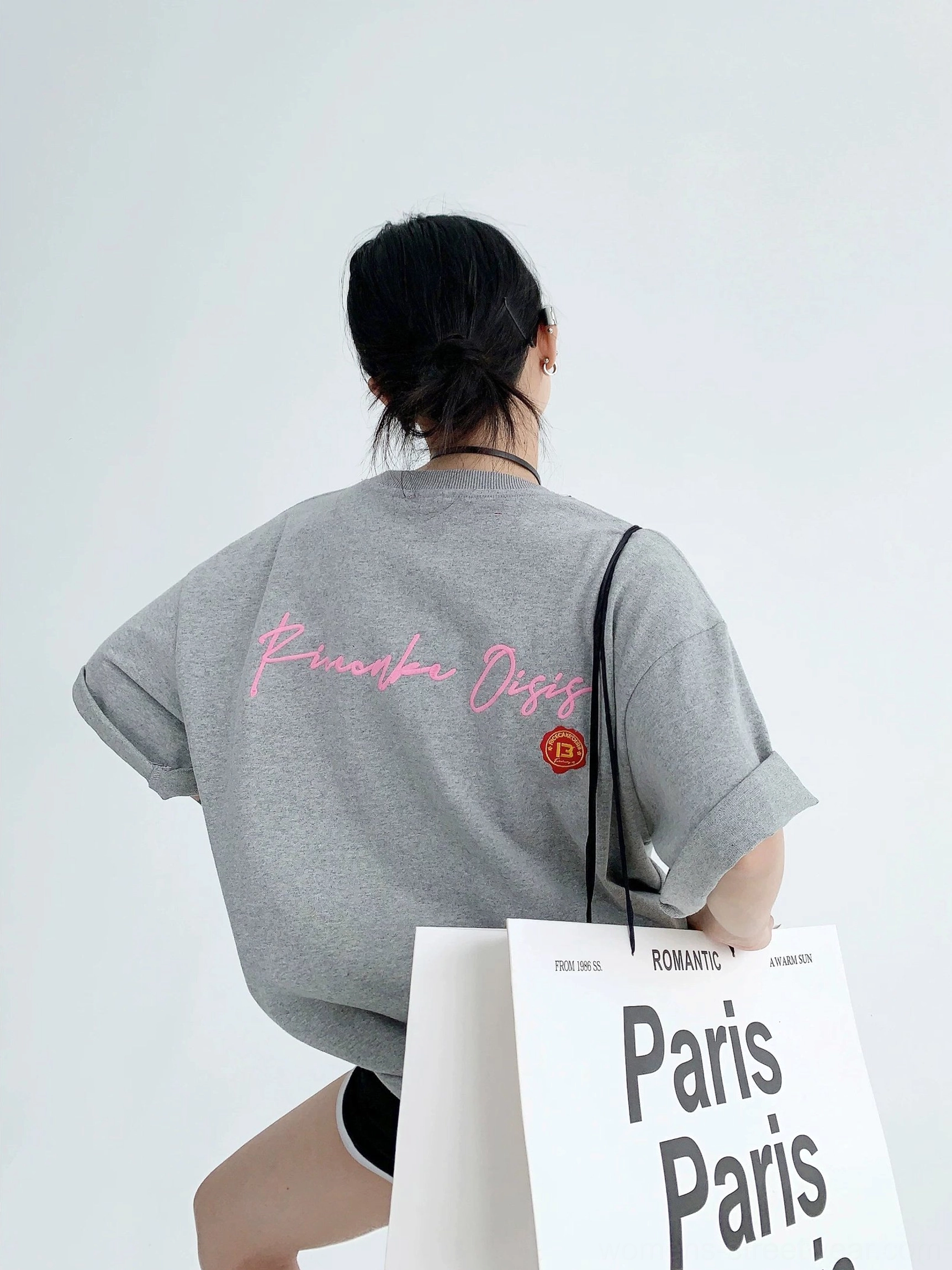 Oversized heather gray neon script graphic tee with pink back lettering, orange emblem, loose fit, and casual Paris tote styling