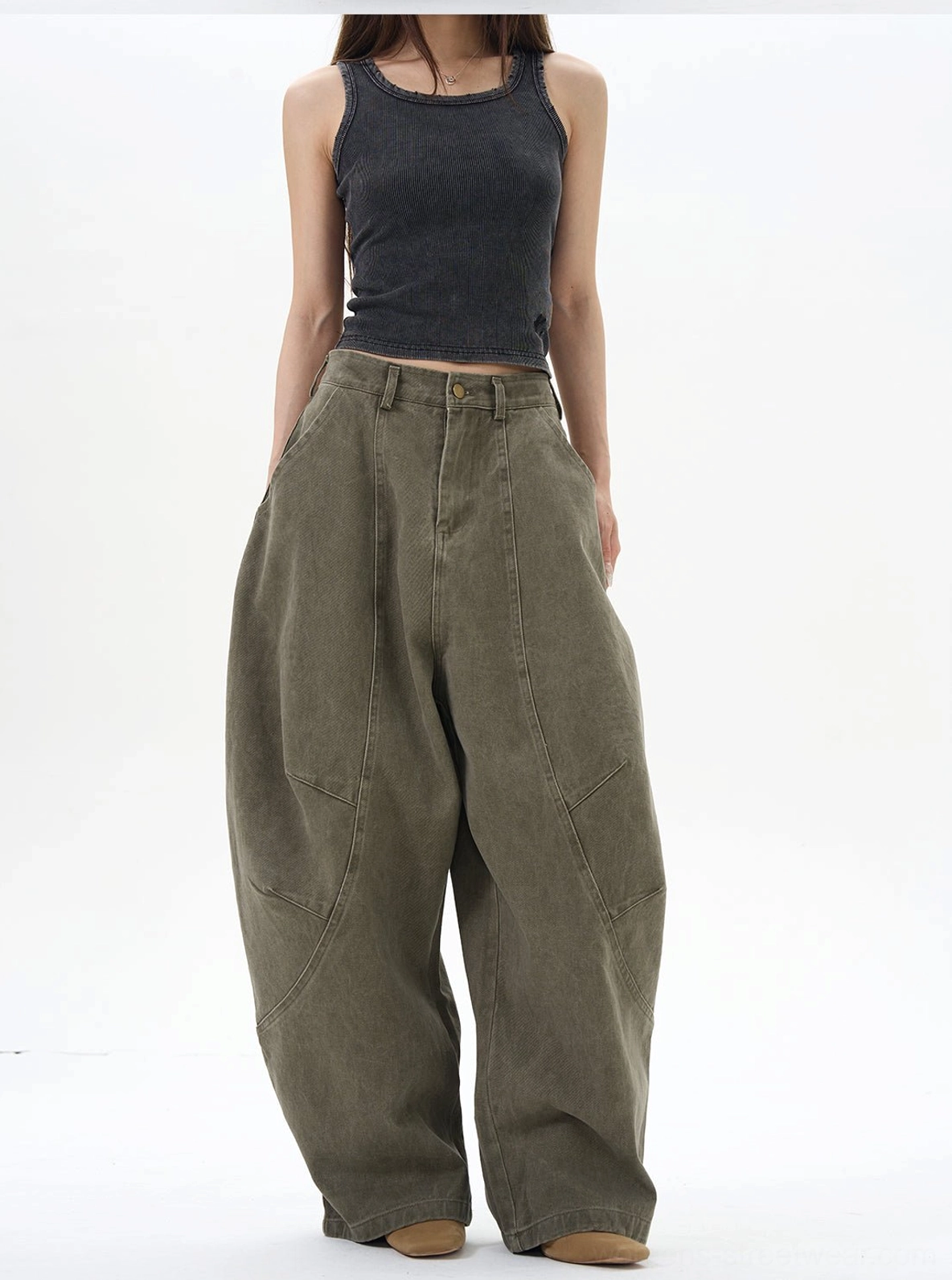 Oversized olive green cargo pants styled with a black tank top for a modern womens streetwear outfit