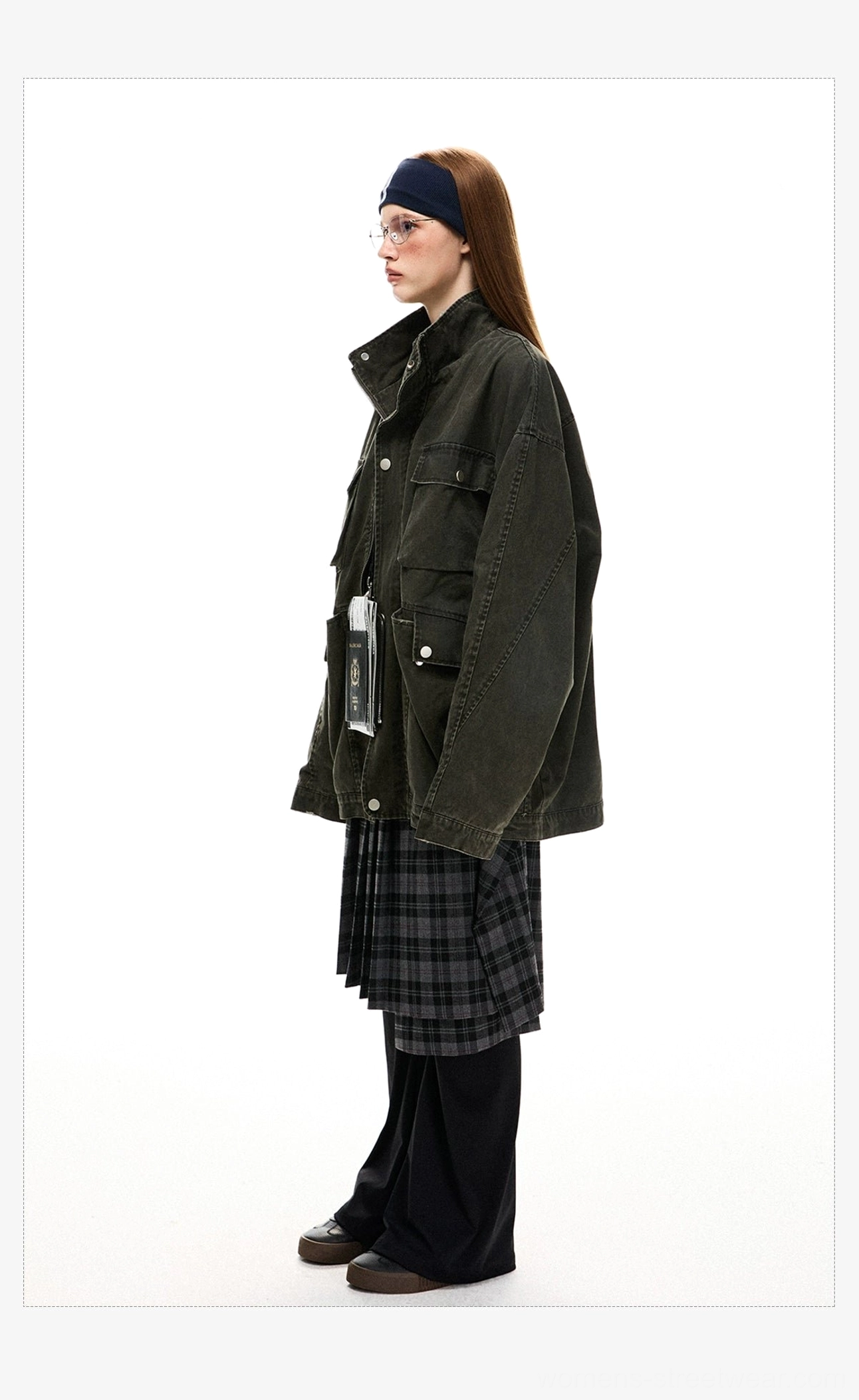 Side profile of an oversized olive green utility jacket showing the relaxed boxy silhouette, stand collar, long sleeve, and side cargo pocket
