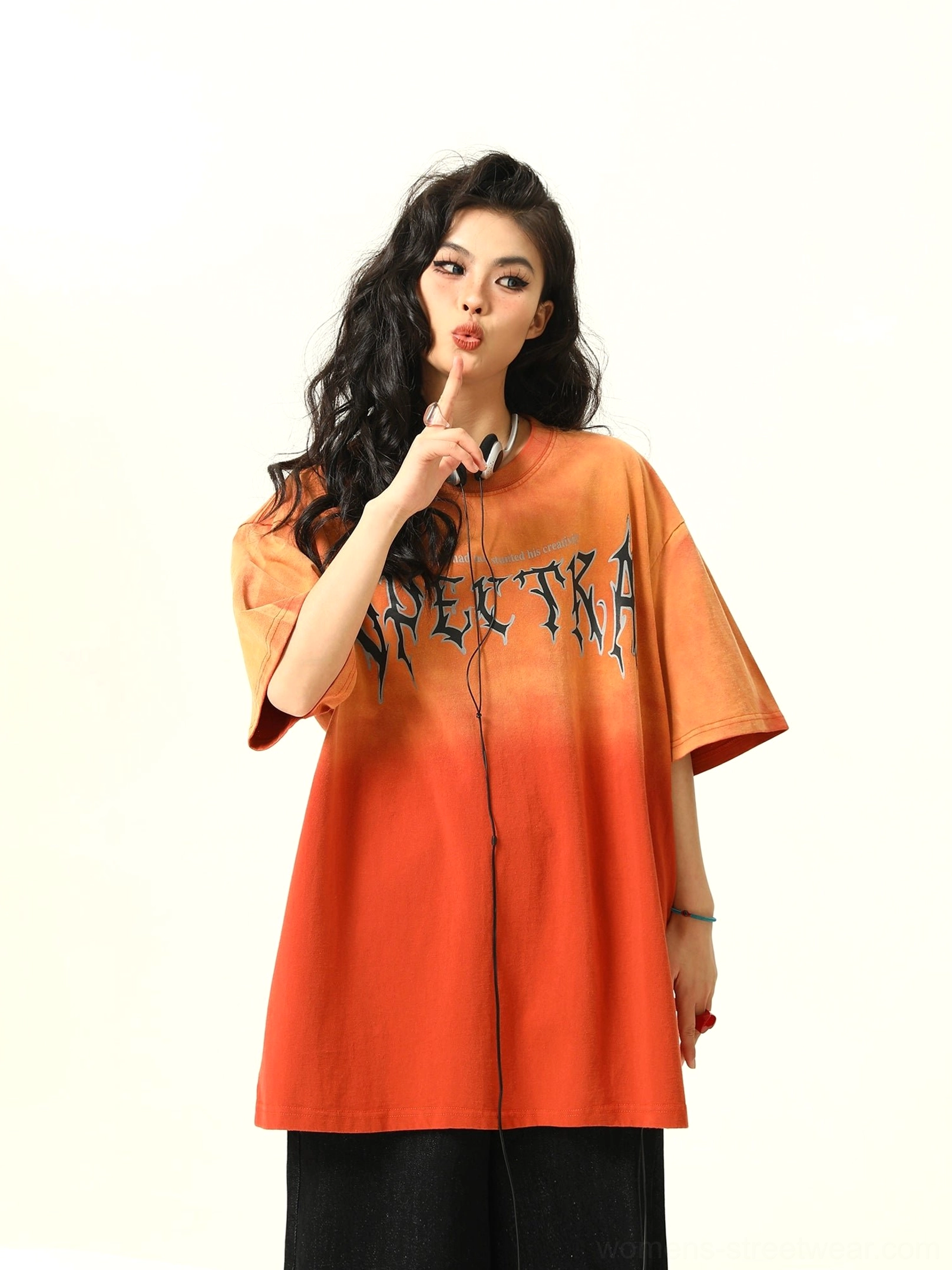 Half body front view of oversized orange ombre graphic tee featuring bold gothic Spectra chest print