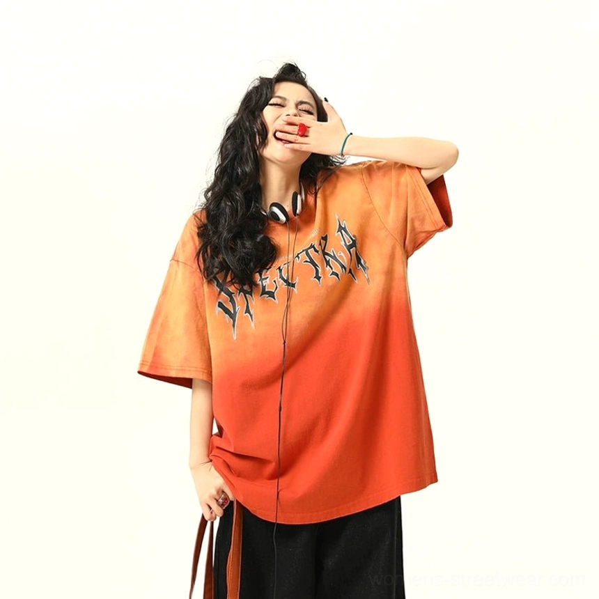 Front leaning view of orange ombre Spectra graphic oversized T-shirt with gothic lettering and loose streetwear fit
