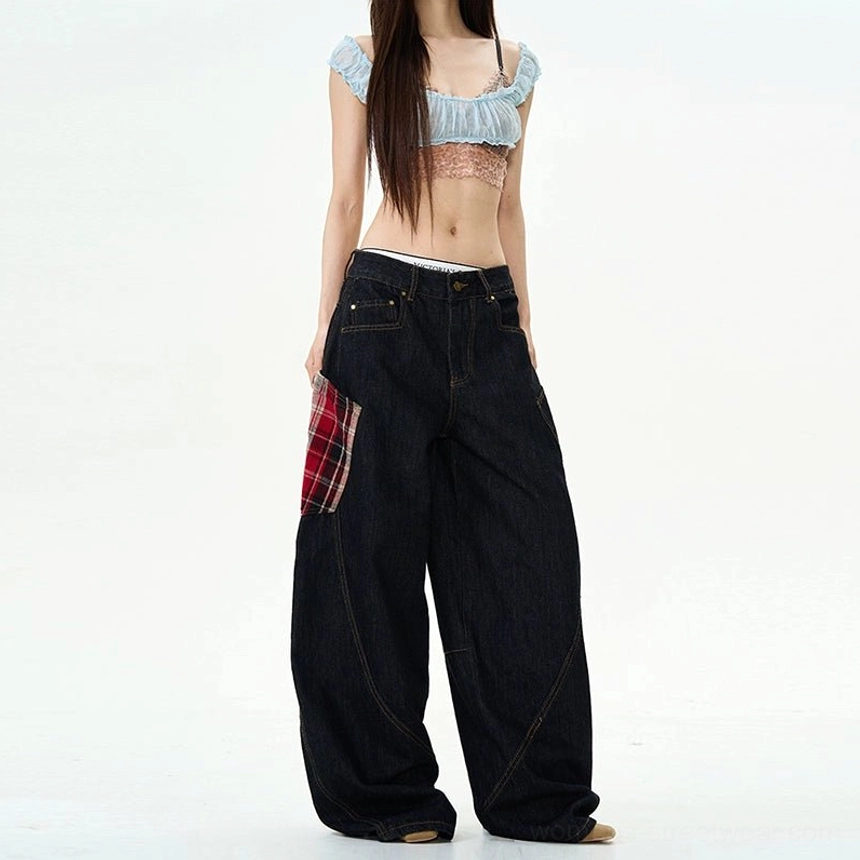 Side front view of oversized plaid patch wide-leg jeans with red plaid cargo pocket and curved tailored denim seams