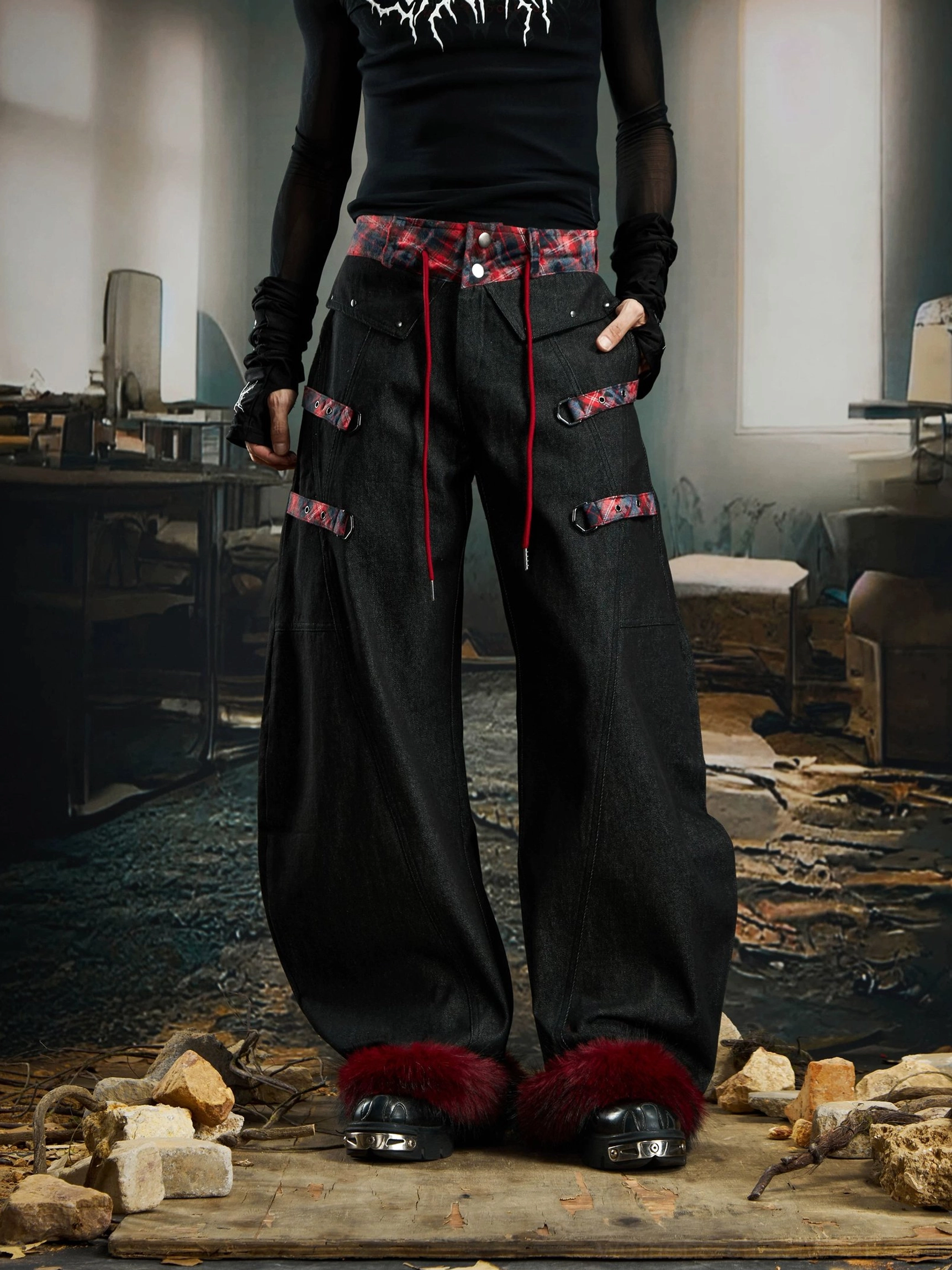 Three-quarter view of oversized punk streetwear cargo pants with plaid waistband multiple leg straps and dark red fluffy cuffs