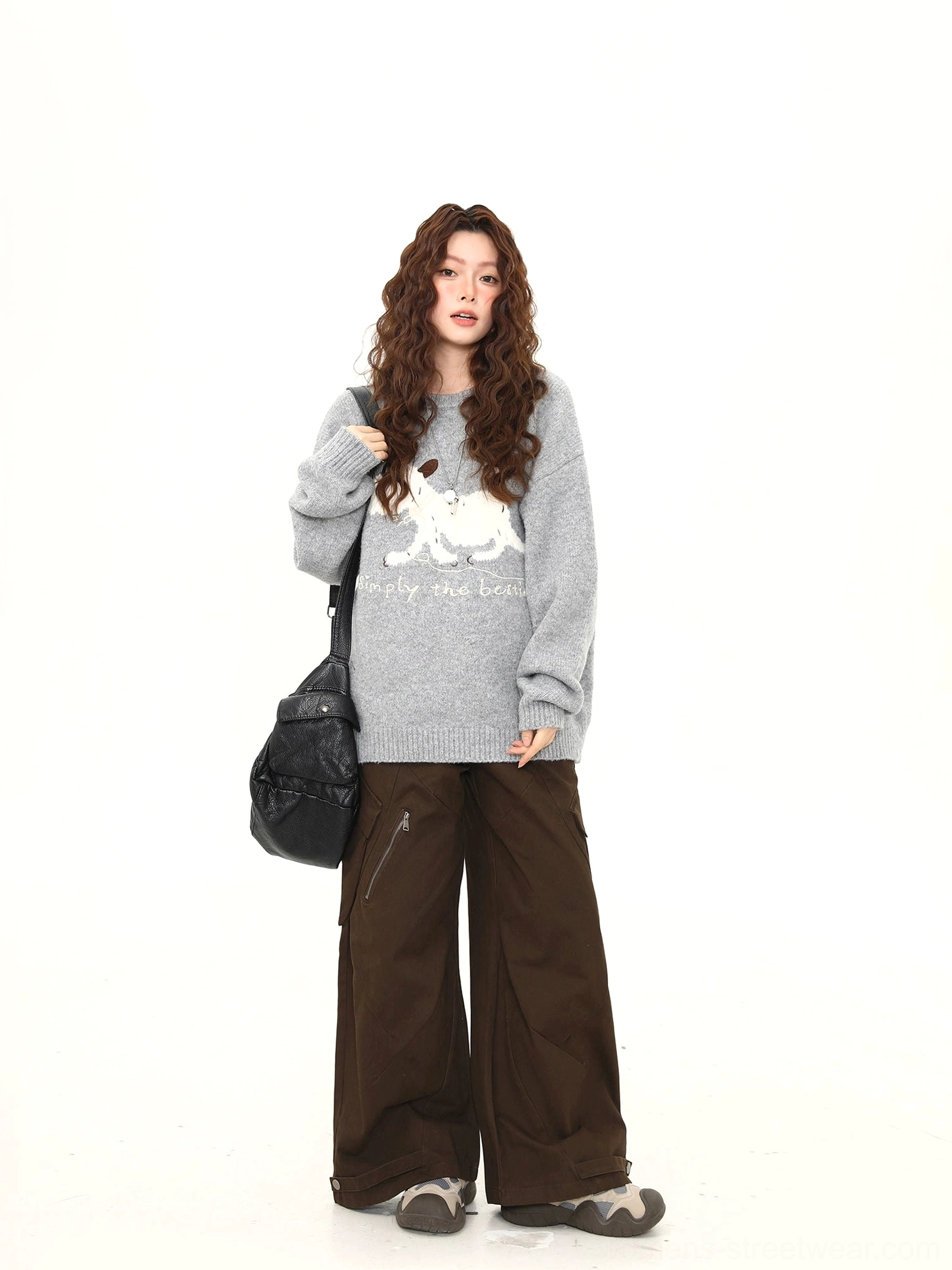 Oversized puppy knit sweater side profile styled with wide-leg cargo pants and black crossbody bag