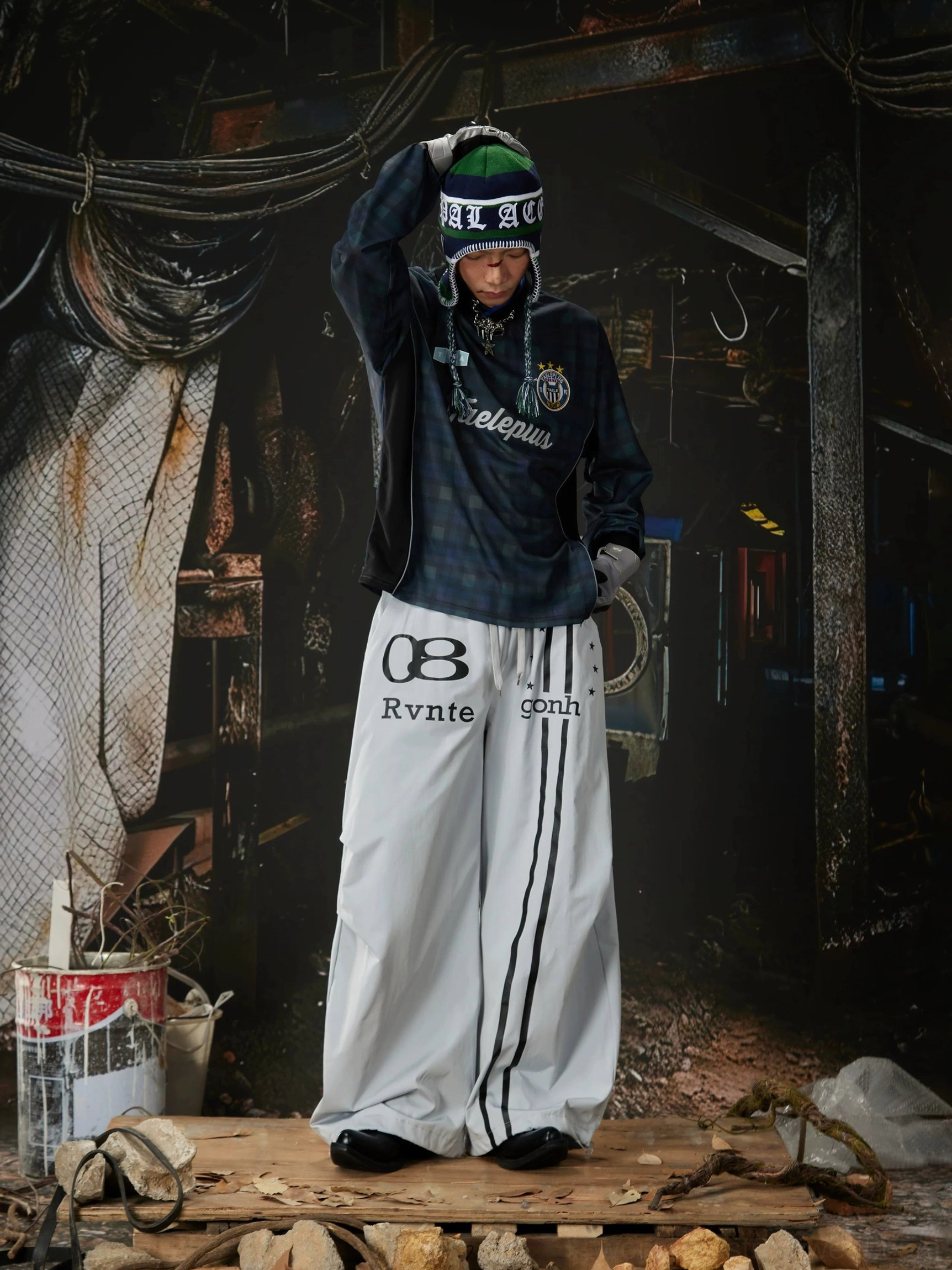 Relaxed oversized track pants with bold racing stripes, graphic lettering, full-length wide legs, and modern Y2K streetwear appeal