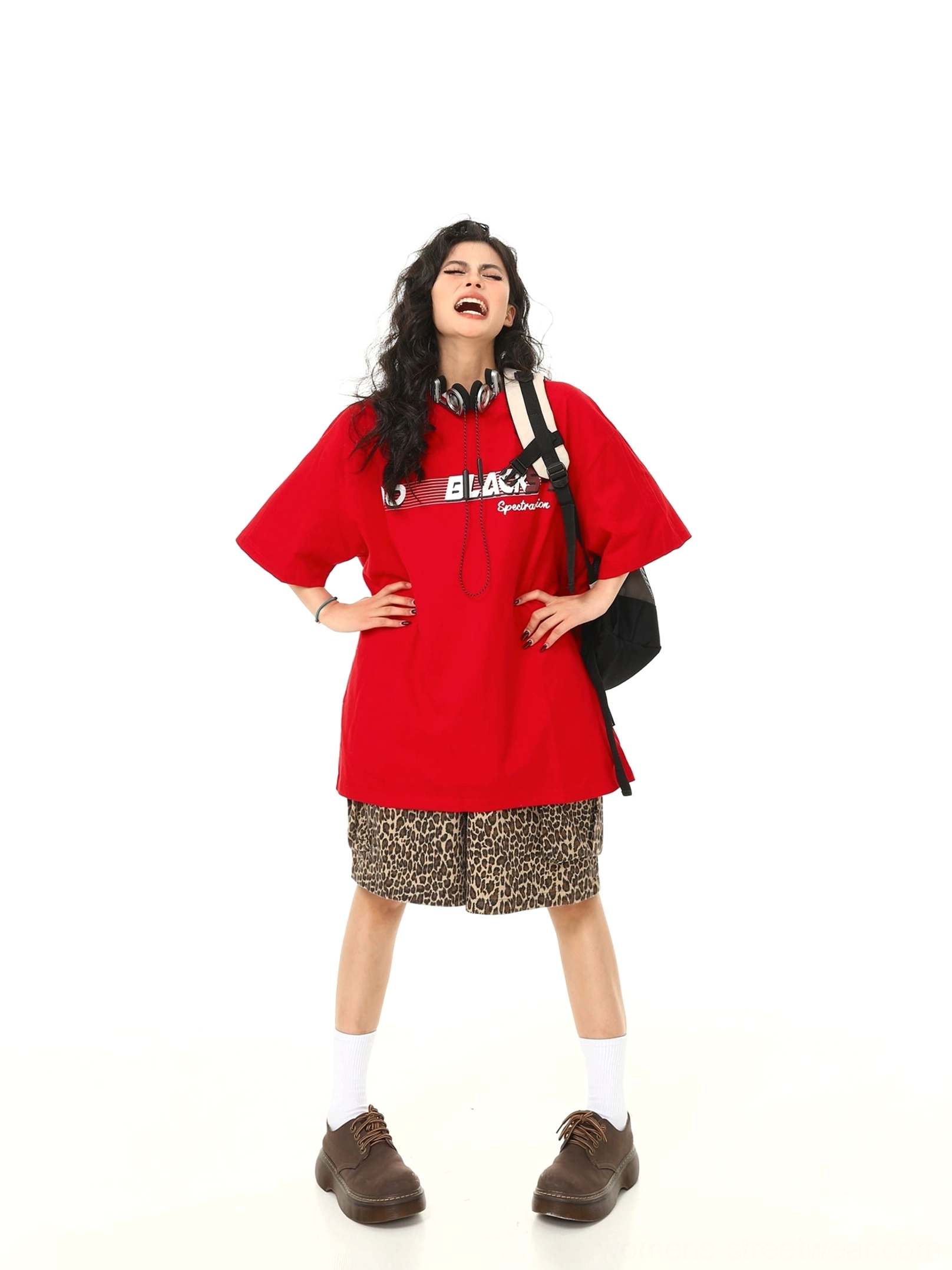 Red oversized retro speed graphic t-shirt styled with leopard print shorts, backpack, and headphones