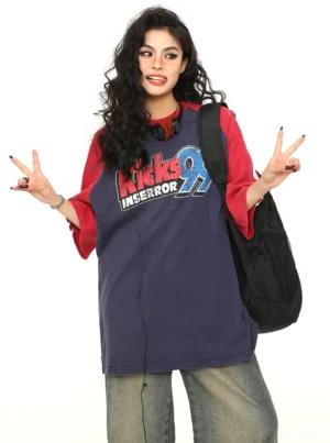 Female model wearing an oversized retro varsity baseball graphic T-shirt with contrast red sleeves and a relaxed streetwear fit