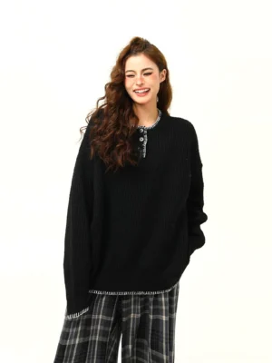 Black oversized ribbed Henley knit sweater with half-button neckline, contrast trim, drop shoulders, and relaxed streetwear fit