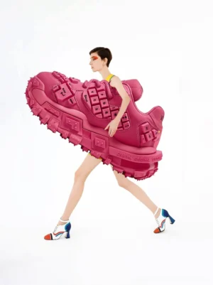 Creative fashion editorial featuring oversized rose pink chunky keyboard sneakers styled with a female model and bold color block footwear