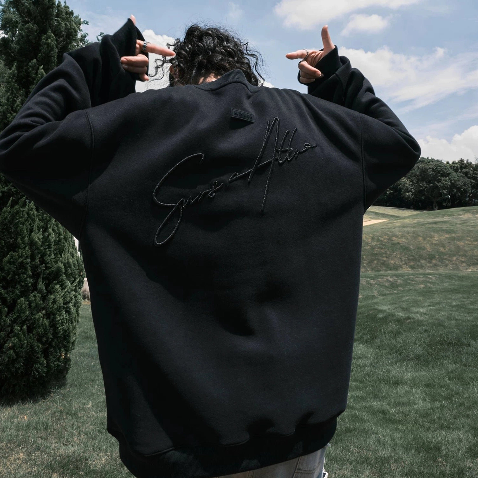 Oversized script embroidered fleece-lined crewneck sweatshirt product image showing the relaxed streetwear silhouette and statement back design