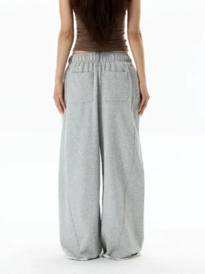 Back view of light gray oversized wide-leg sweatpants with elastic drawstring waist, rear patch pockets, and relaxed Korean streetwear fit