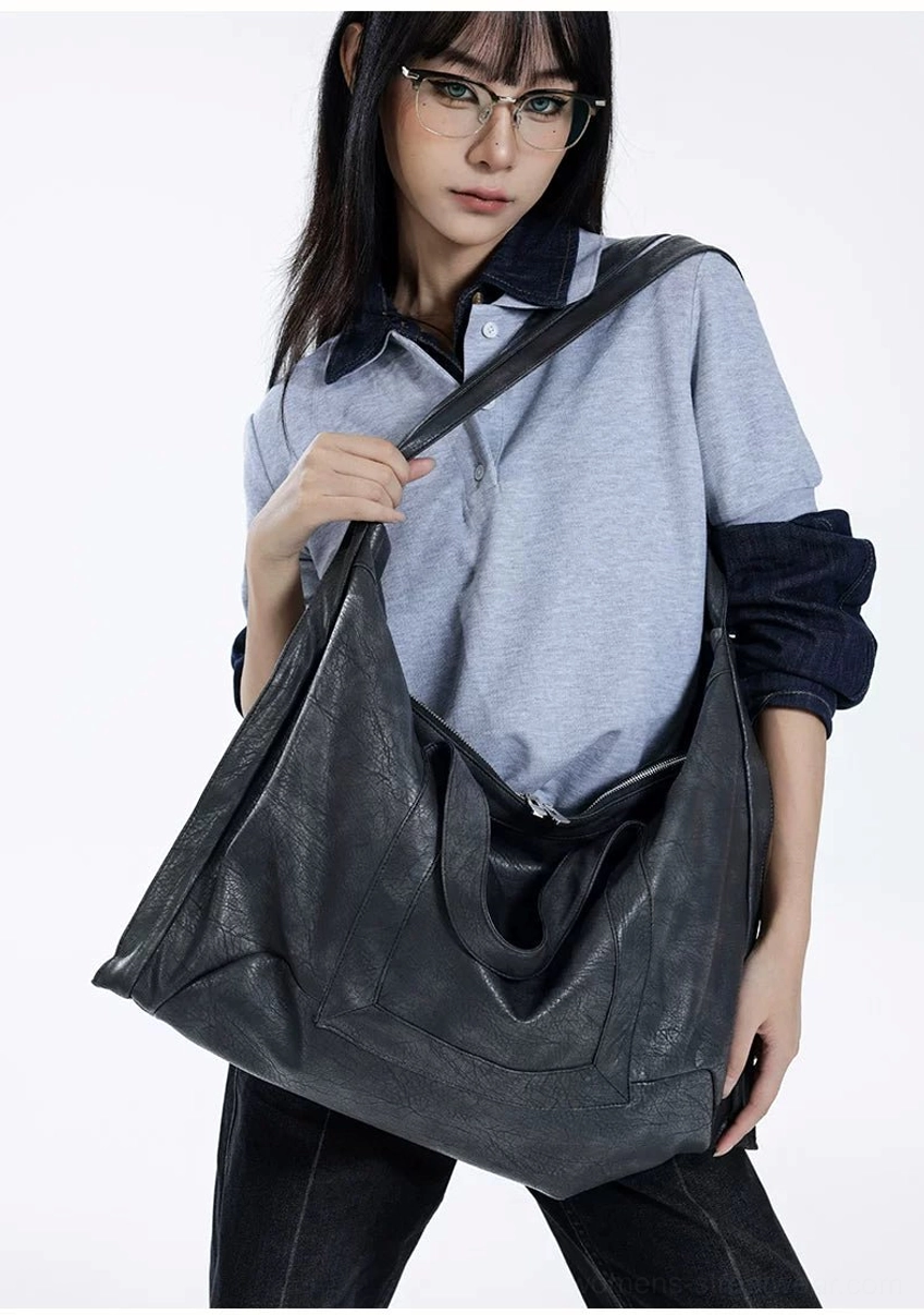 Shadow Drape oversized slouchy tote bag in dark matte faux leather held upright by studio model