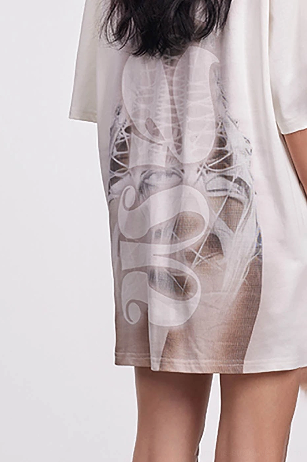 Close back view of an oversized skeleton mesh tee showing spine illustration, stylized lettering, and brown gradient artwork